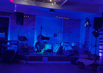 blaue Bühne mit Instrumenten, Hochzeitsmusik Voices And Music, Oberösterreich, Linz, Kontrabass, Schlagzeug, Keyboard, Gitarre, Saxofon, Bühnenscheinwerfer